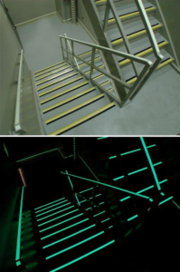 Staircase with photoluminescent strips applied. Top photo in light, bottom photo in dark, showing stair treads glowing.