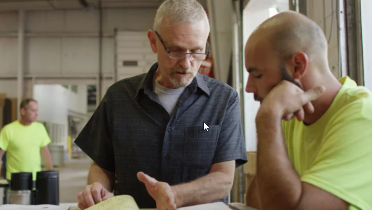 Alpha Insulation and Waterproofing technicians talking together in large warehouse building.