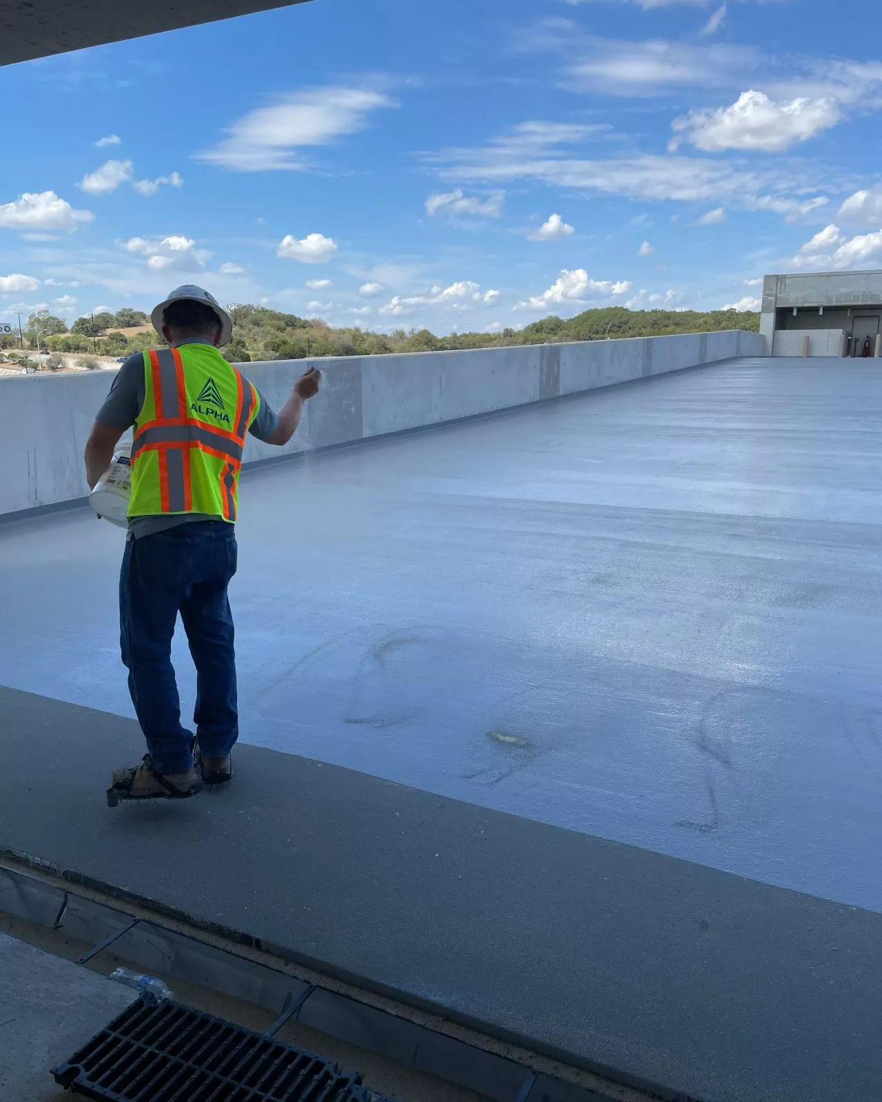 Worker reviewing parking garage with traffic coating applied
