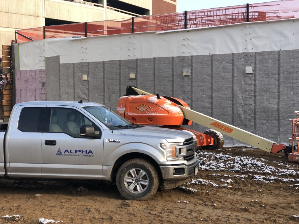 Waterproofing system installation. Alpha service truck on construction site.
