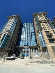 fluid applied air barrier on high-rise buildings, view from the ground looking up, blue sky behind.